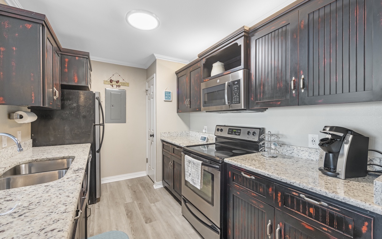 Your fully equipped kitchen features granite countertops, stainless steel appliances, and rich dark cabinetry for preparing memorable meals together.