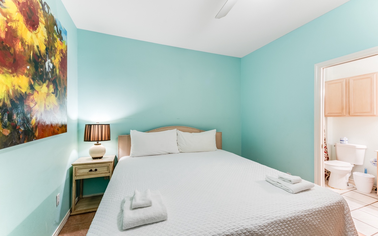 Sink into crisp linens and let the cheerful sunflower art brighten your mornings in this tranquil turquoise retreat.