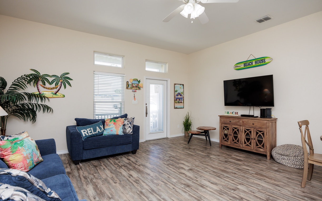 Sink into navy sofas surrounded by tropical decor in your bright living room, where beach vibes meet modern comfort.