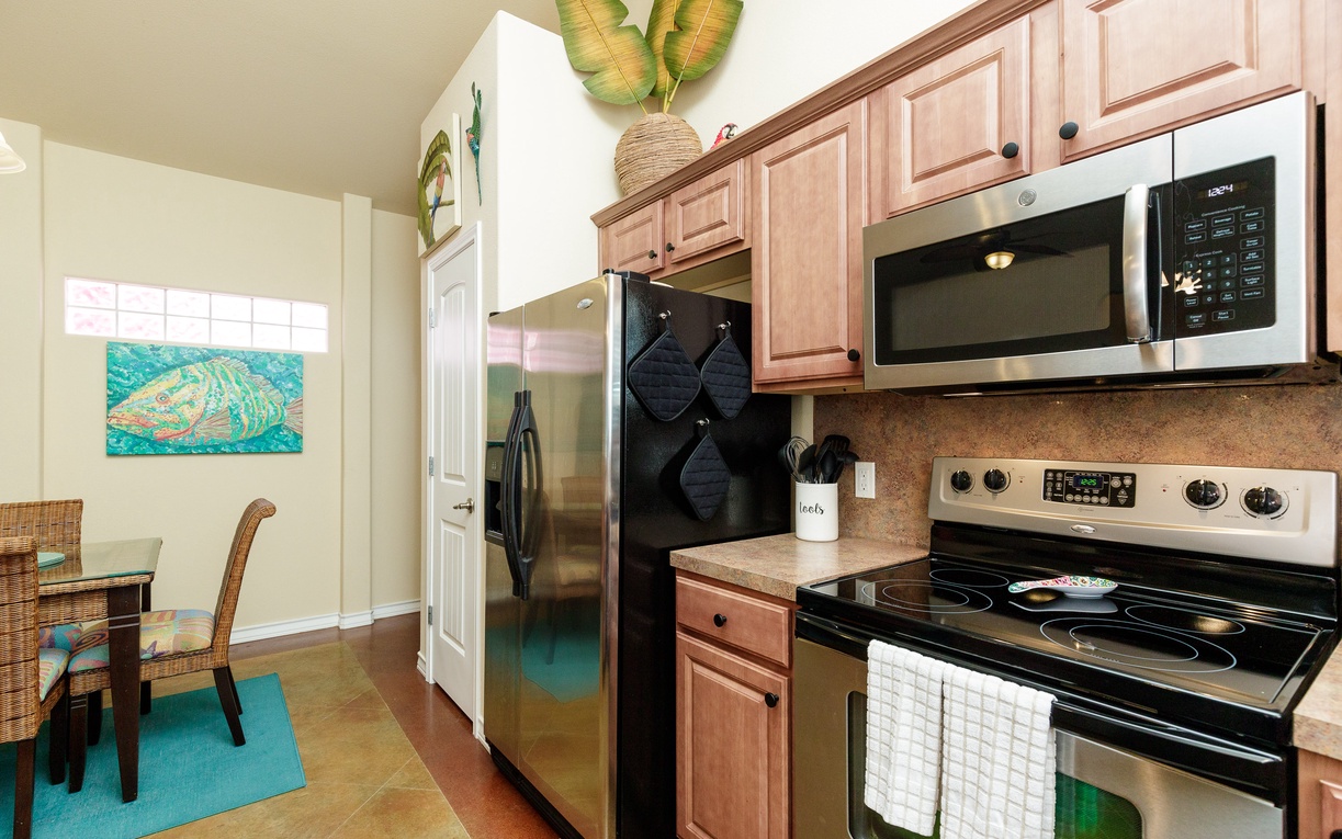 Your fully equipped kitchen features stainless steel appliances and warm wood cabinetry, perfect for preparing meals during your stay.