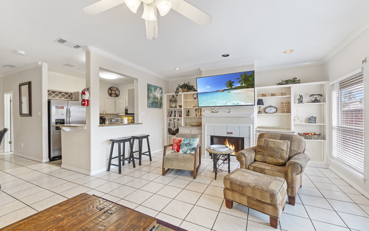 Unwind in your open-plan living space with cozy fireplace, large TV, and stylish kitchen—perfect for relaxing after your adventures.