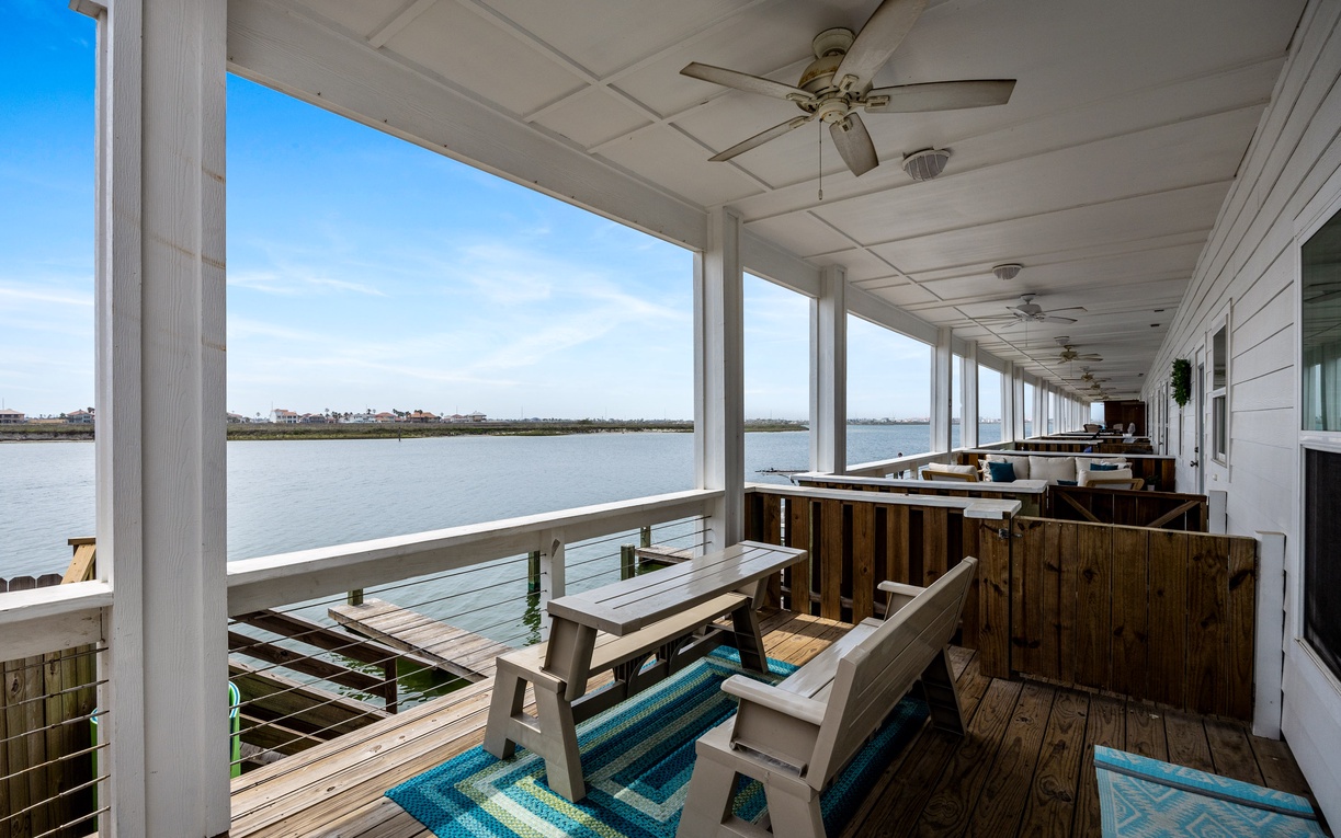 Your waterfront balcony invites relaxation with comfortable seating and stunning lake views stretching to the horizon.