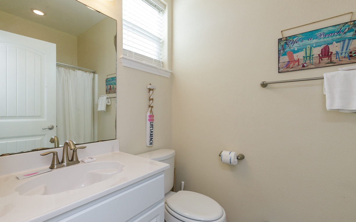 Well-appointed primary bathroom with natural light streaming through the window.