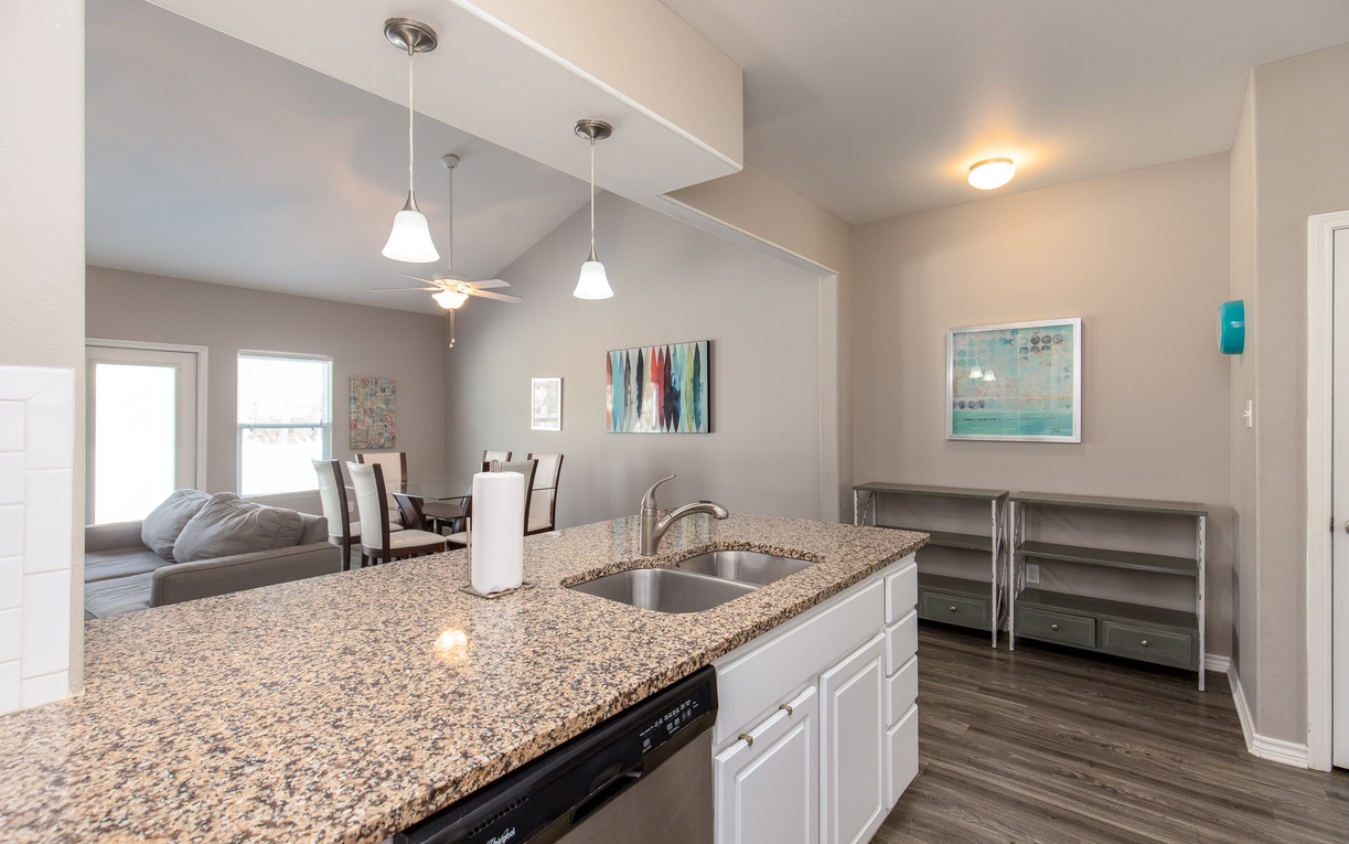 Your modern kitchen island flows seamlessly into the bright dining and living spaces, perfect for entertaining.