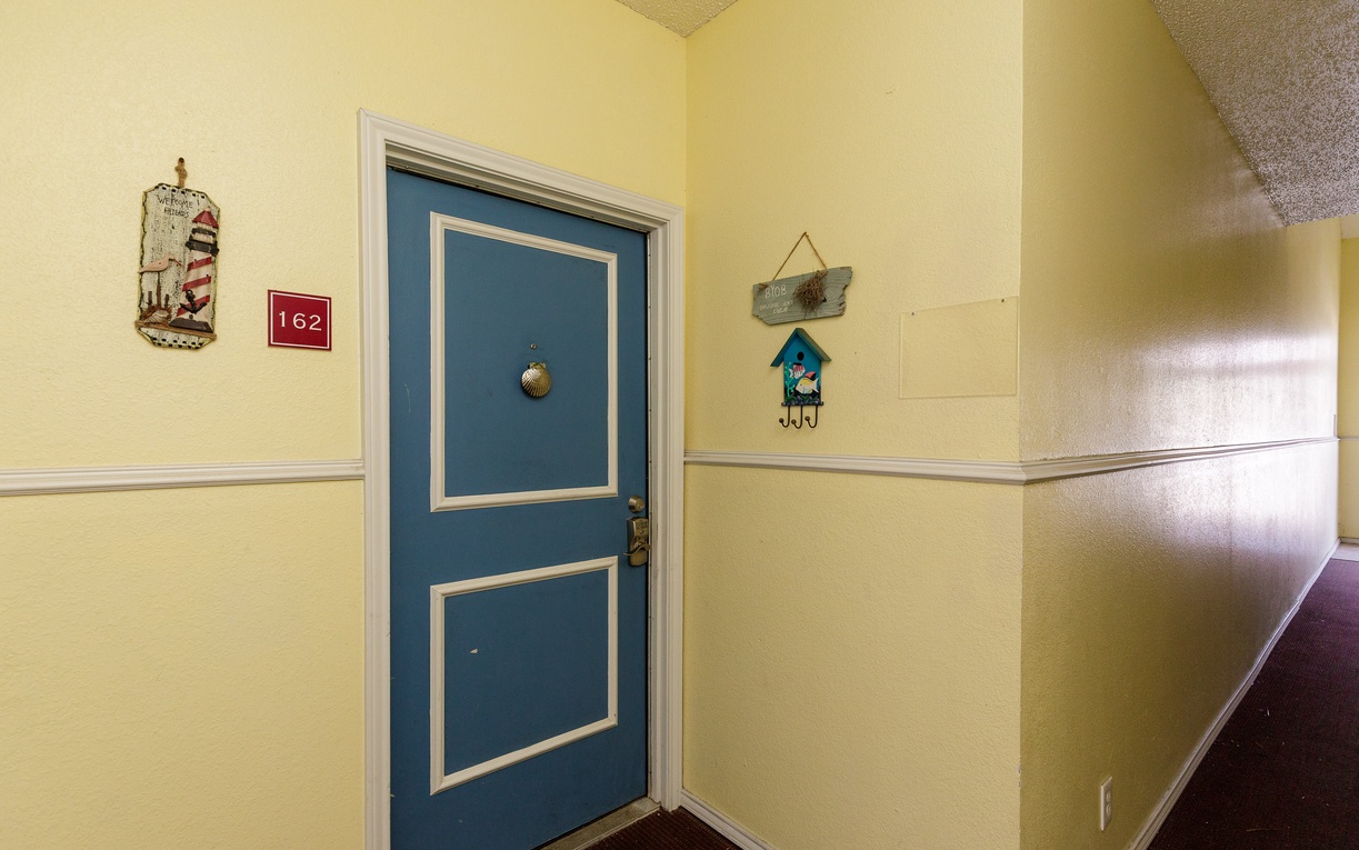 Your charming room awaits behind this welcoming blue door, adorned with thoughtful nautical touches that set a cozy seaside mood.
