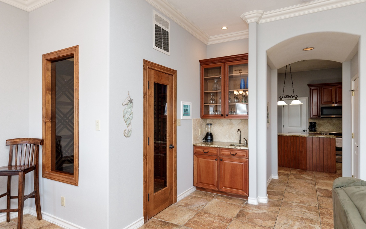 Your elegant wet bar awaits with rich wood cabinetry and granite countertops, perfect for mixing drinks while entertaining.