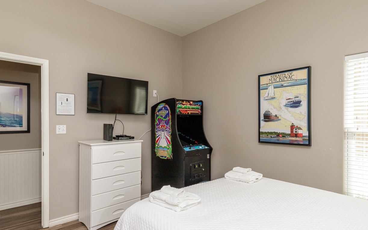 Your cozy bedroom features arcade games for entertainment, wall-mounted TV, and fresh linens for ultimate relaxation.