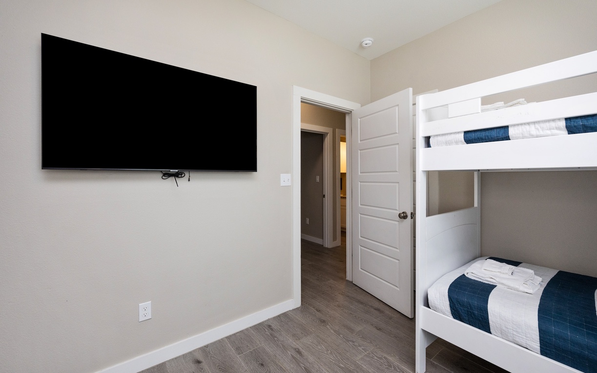 Your kids will love this cozy bunk room with wall-mounted TV for evening entertainment and crisp white linens for peaceful sleep.