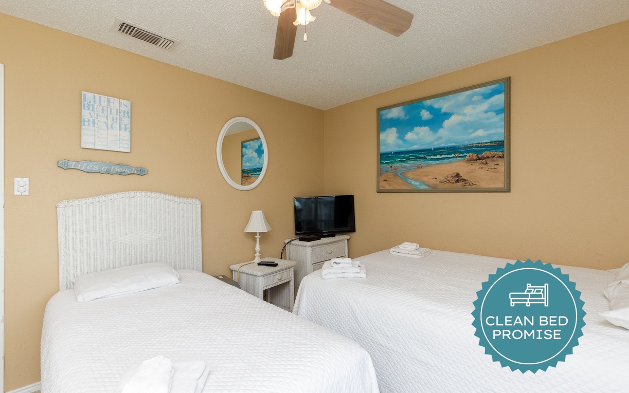 Rest peacefully in this coastal-themed bedroom with two comfortable beds and beachside artwork that brings ocean tranquility indoors.