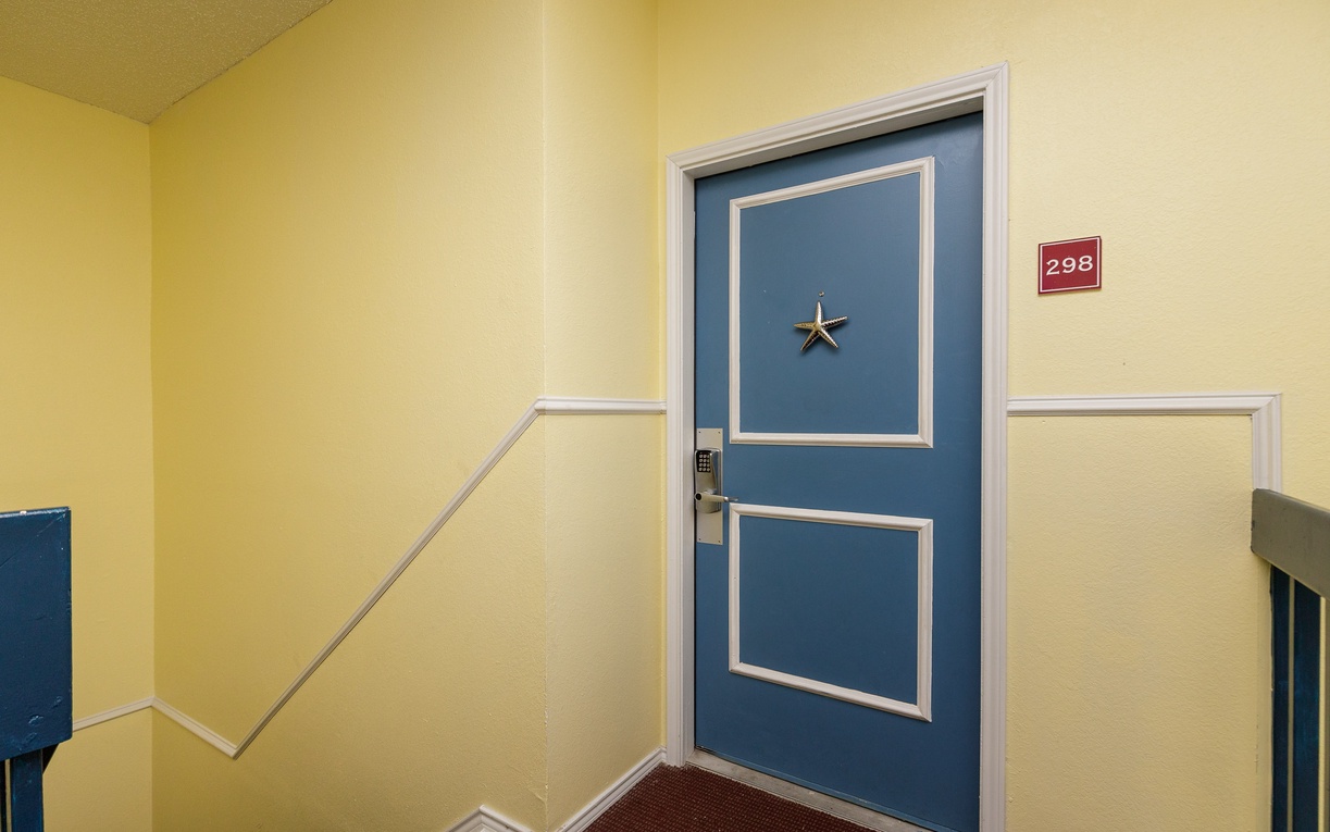 Your coastal retreat awaits behind this charming blue door, adorned with a starfish that hints at the seaside adventures ahead.