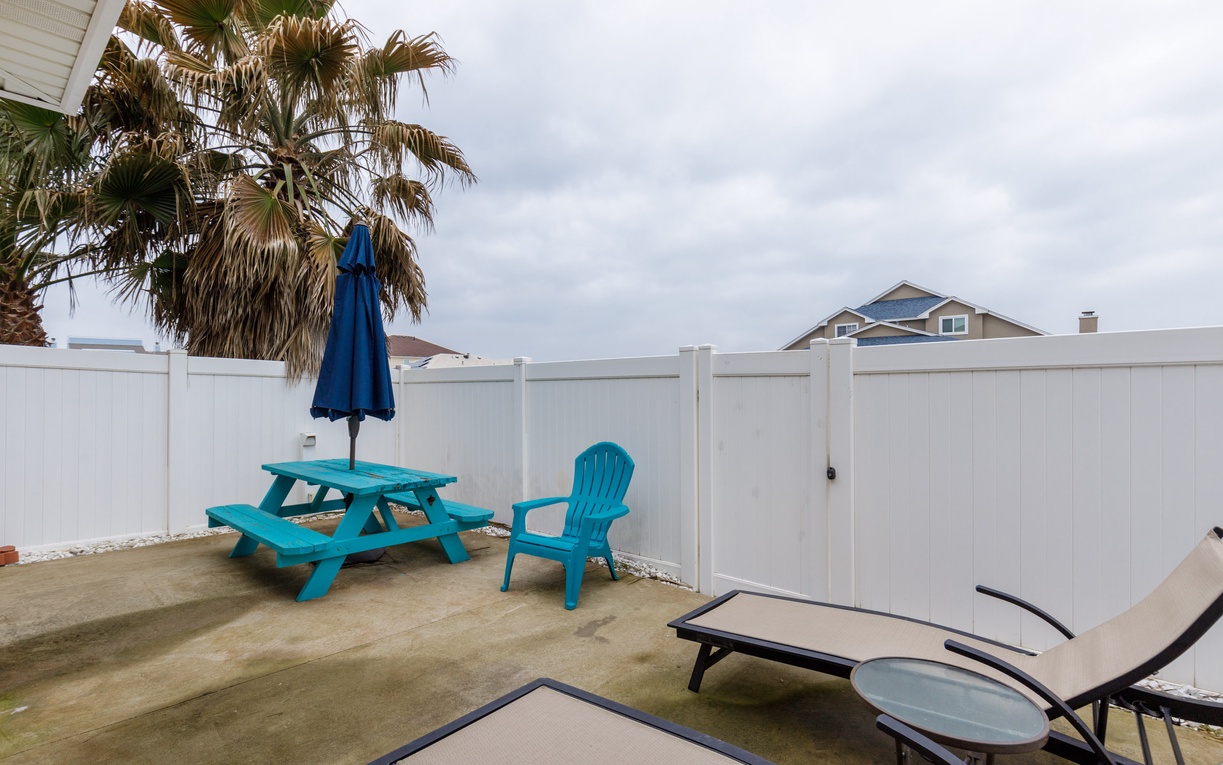 Your private patio offers turquoise furniture, loungers, and tropical palms for perfect outdoor relaxation.