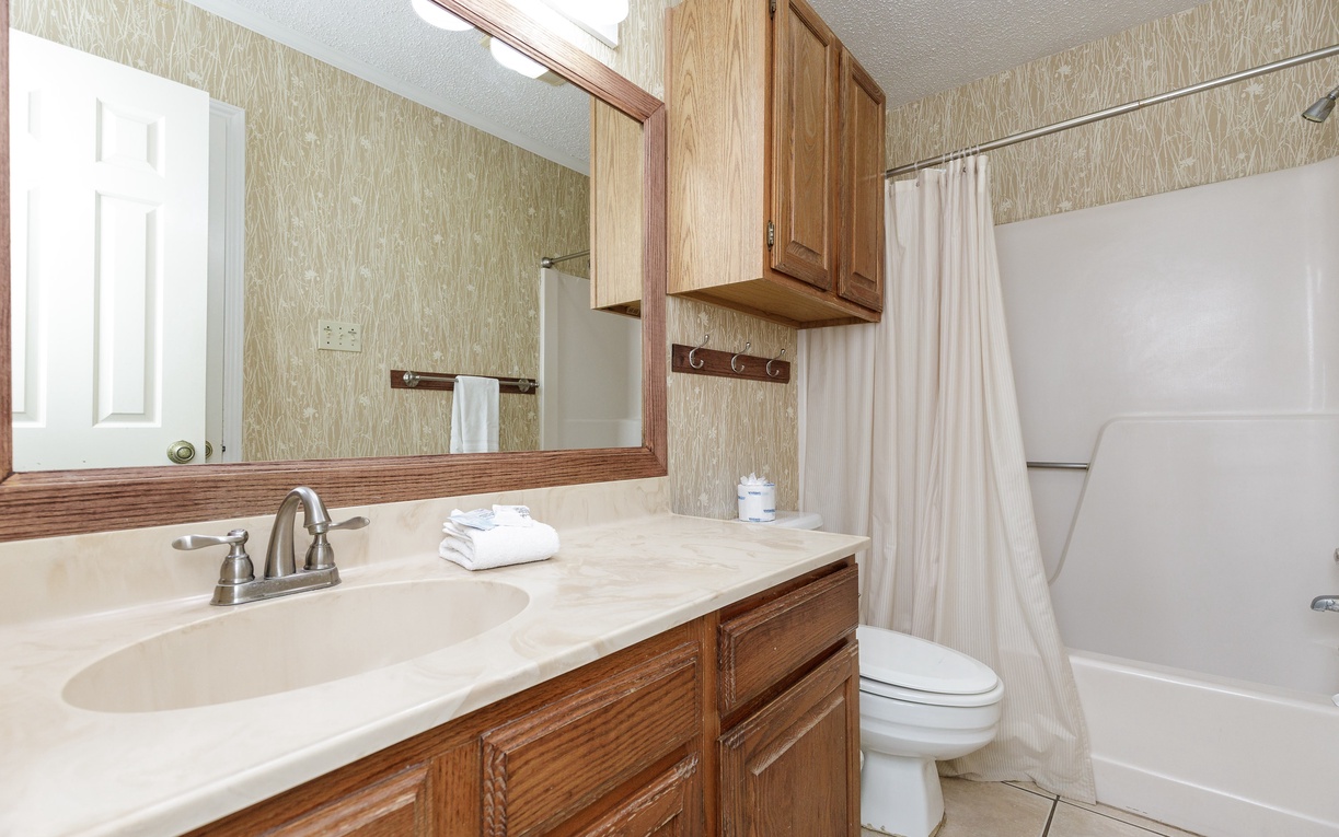 Your bathroom features warm wood cabinets, fresh towels, and a convenient tub-shower combo for relaxing after your adventures.