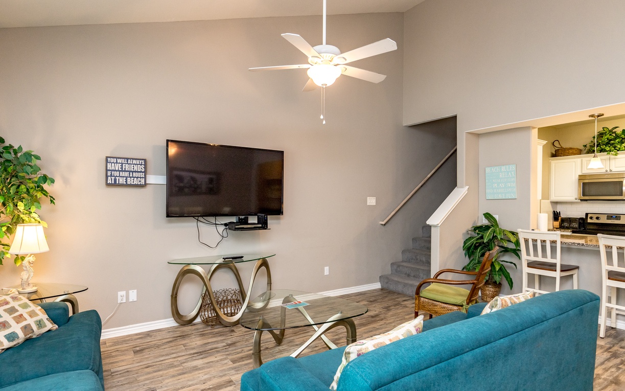 Relax in your bright living area with vibrant turquoise seating, modern amenities, and an open layout perfect for unwinding after beach adventures.