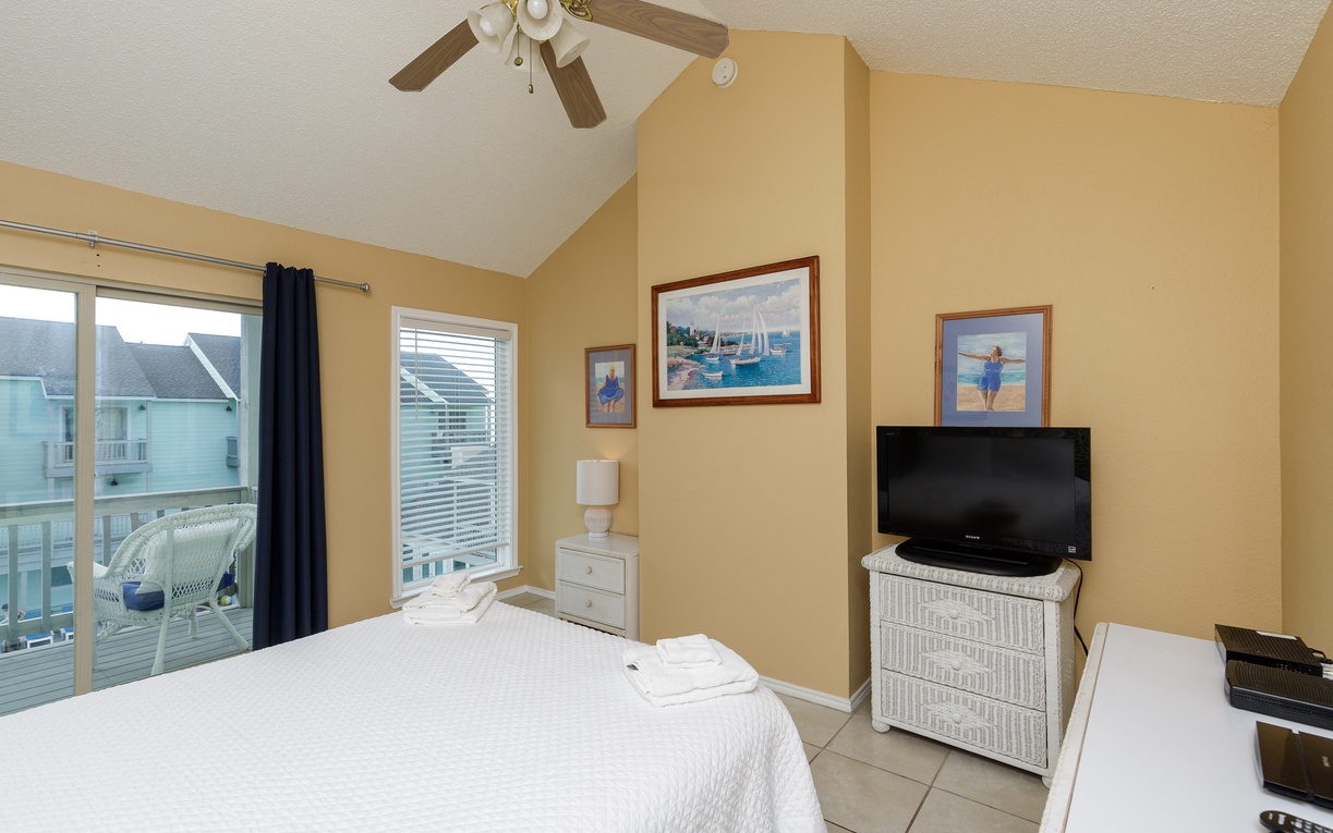 Your coastal bedroom features a comfortable bed, flat-screen TV, and private balcony access where you can unwind with ocean-themed decor surrounding you.