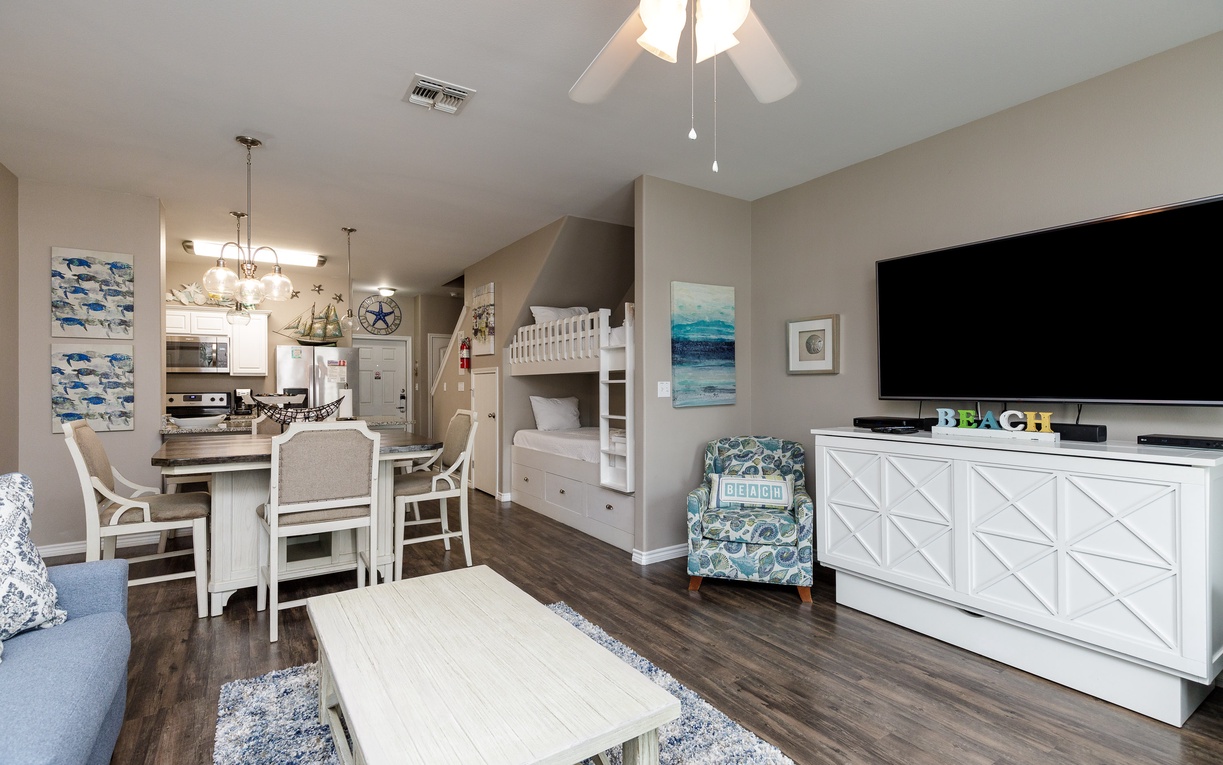 Your coastal-themed living space seamlessly blends comfort with function, featuring bunk beds and an open kitchen perfect for family gatherings.