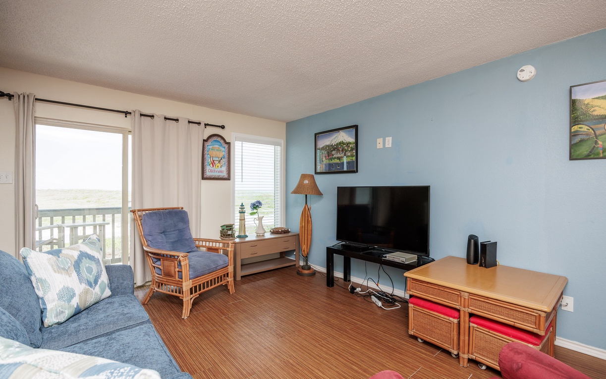 Relax in your cozy living room with ocean views, comfortable seating, and entertainment center for perfect vacation moments.