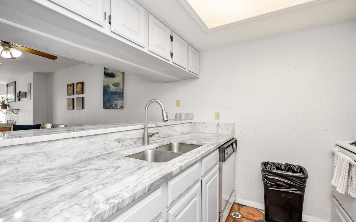 Cook comfortably in your bright galley kitchen with marble countertops, stainless steel appliances, and plenty of cabinet storage.