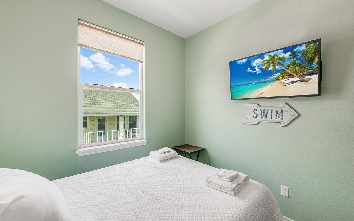Drift off in your serene bedroom, where calming green walls and tropical art transport you to paradise.
