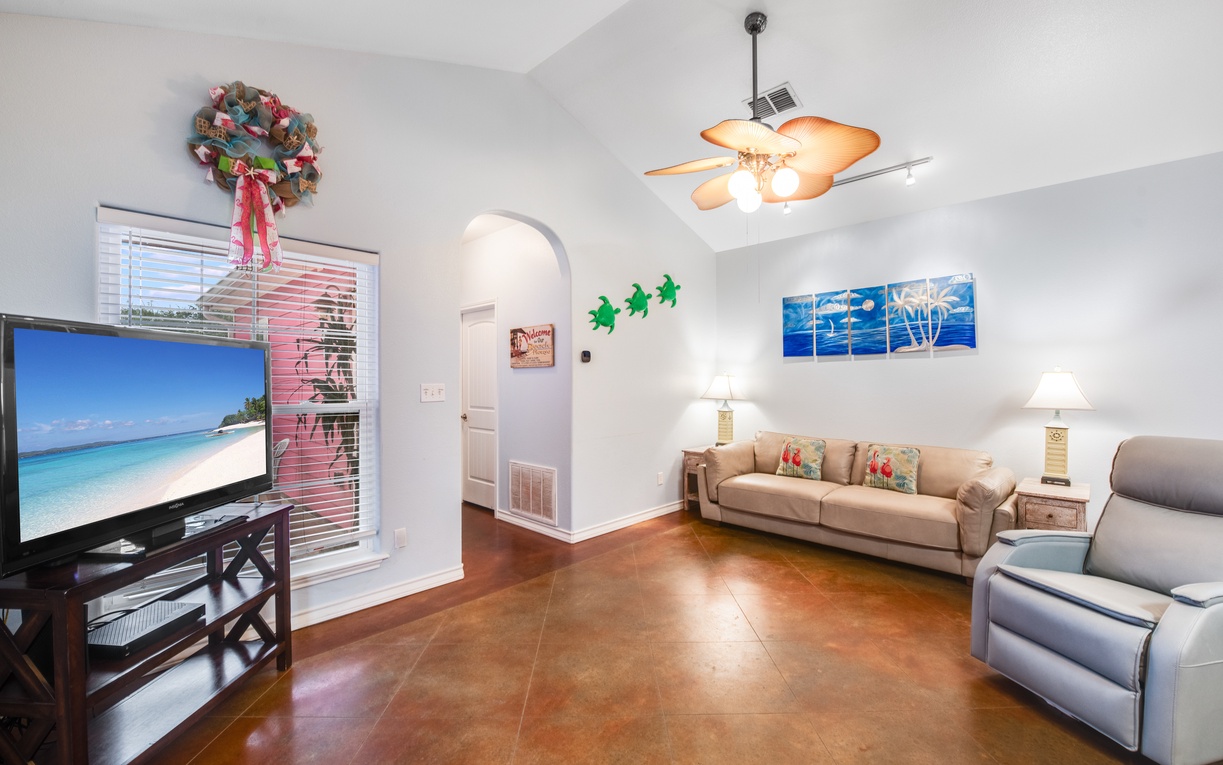 Unwind in this bright living room with comfortable seating, large TV, and tropical touches that make you feel instantly at home.