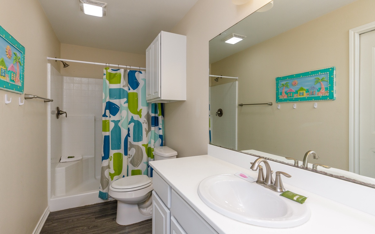 Your bright, cheerful bathroom features a refreshing tub-shower combo and vibrant tropical artwork to start your mornings right.