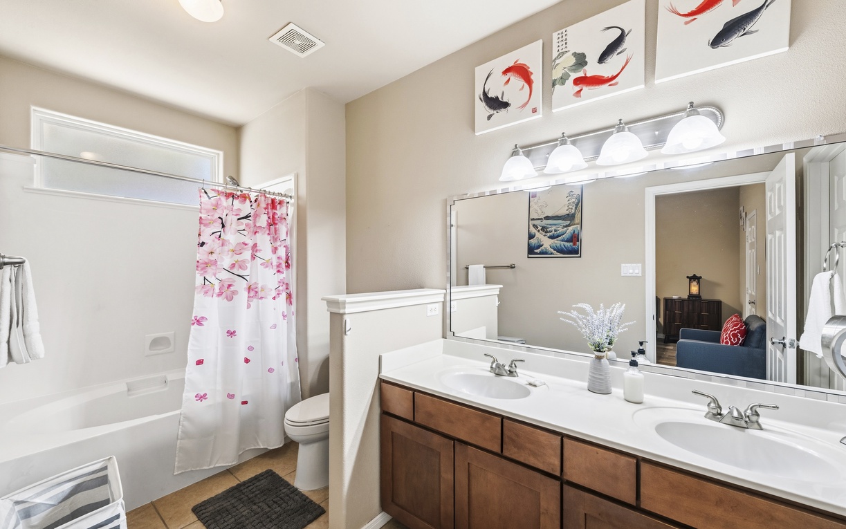 Your bright, thoughtfully designed bathroom features dual sinks and Asian-inspired koi artwork, creating a serene space to refresh before your next adventure.