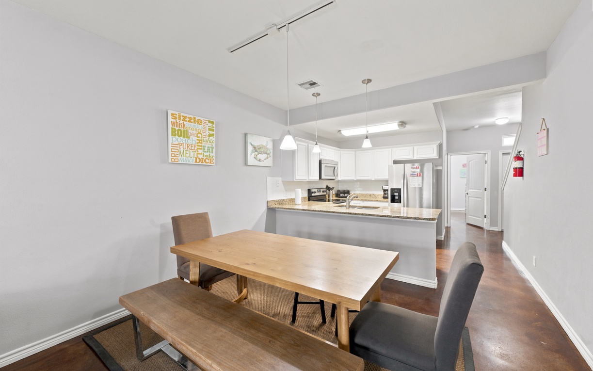 Gather around a welcoming dining table that flows seamlessly into your fully equipped kitchen, with granite countertops and modern appliances at your fingertips for easy meal prep.