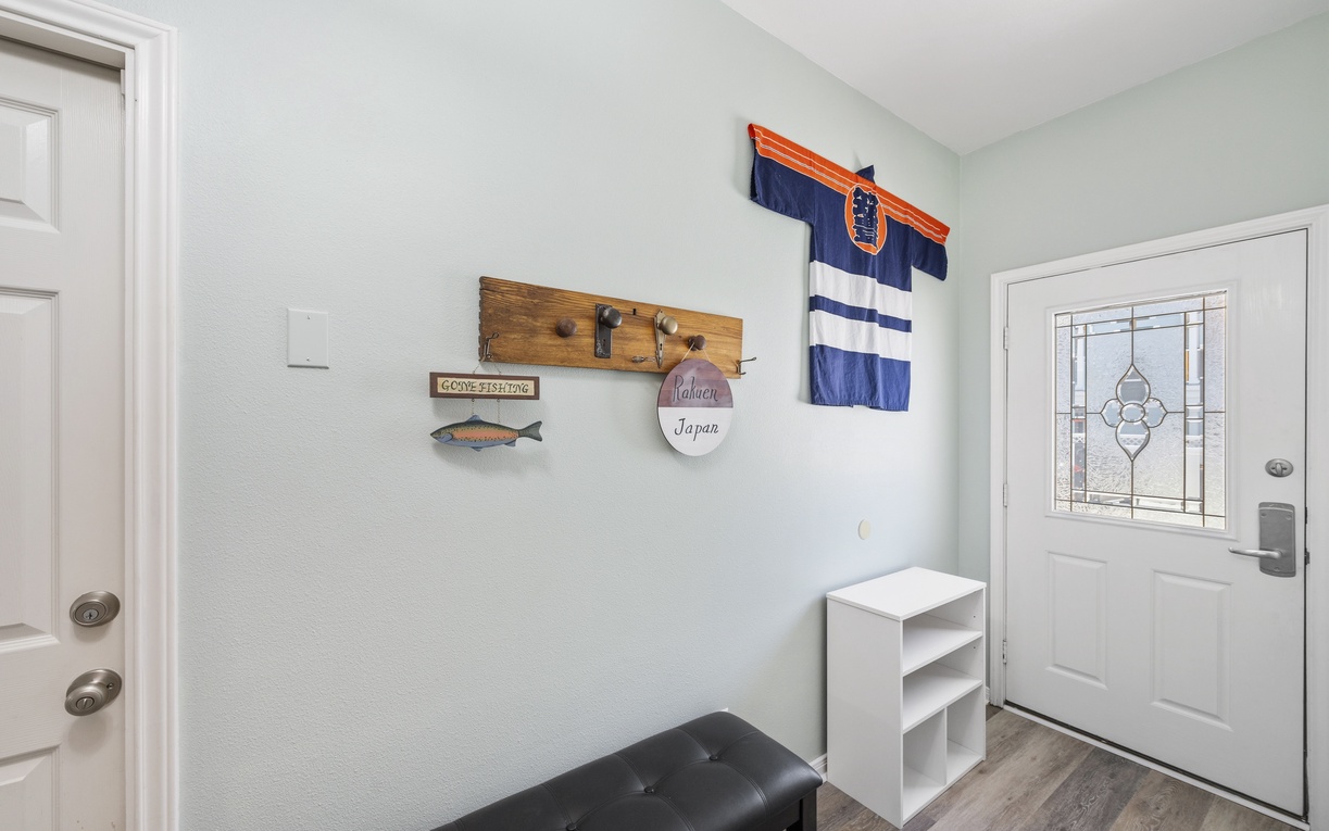 A welcoming entryway greets you with charm—rustic hooks ready for your coats, crisp storage for your shoes, and Asian decor setting a relaxed, comforting vibe from the moment you step inside.