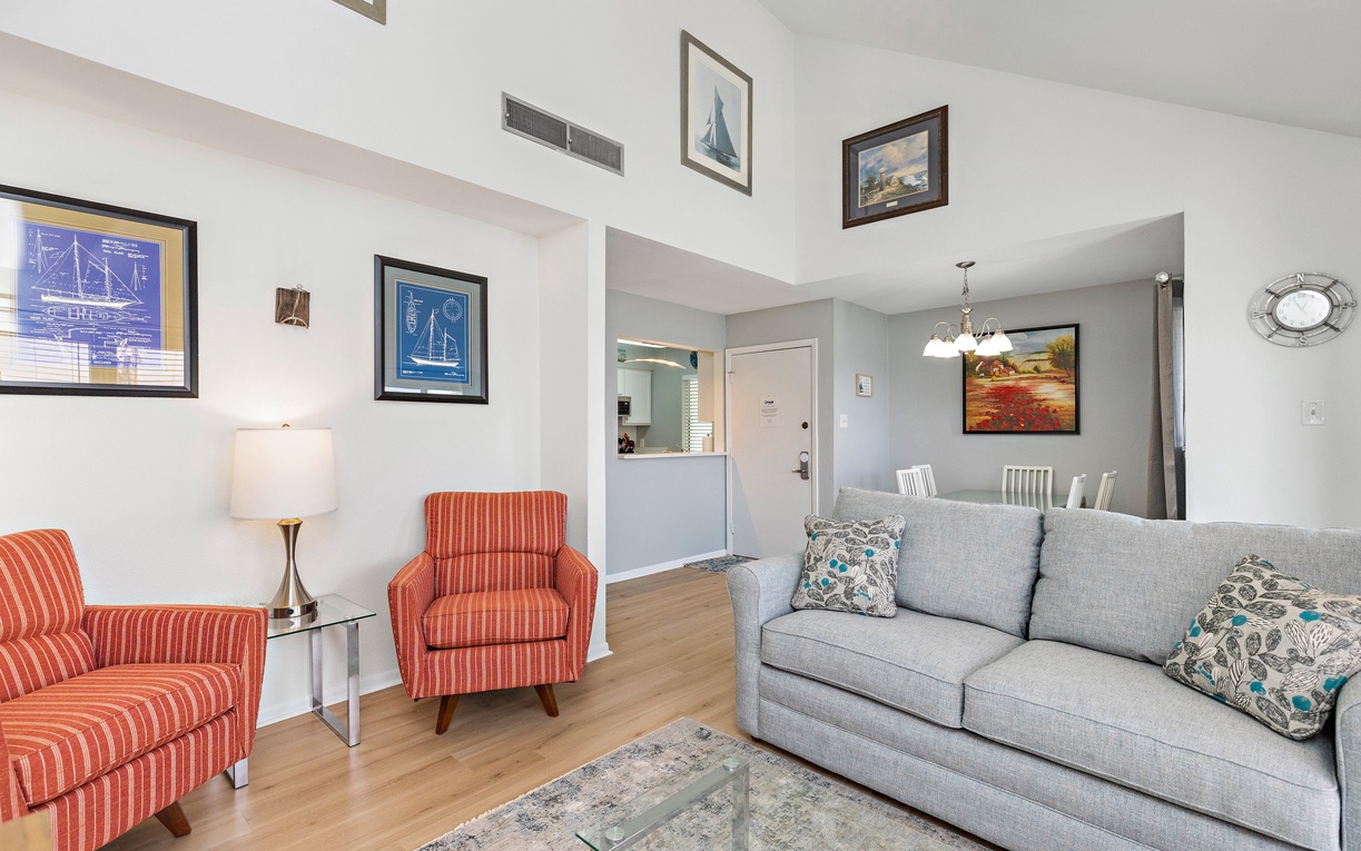 Settle into your bright living space with comfortable seating and nautical artwork creating a coastal retreat atmosphere.