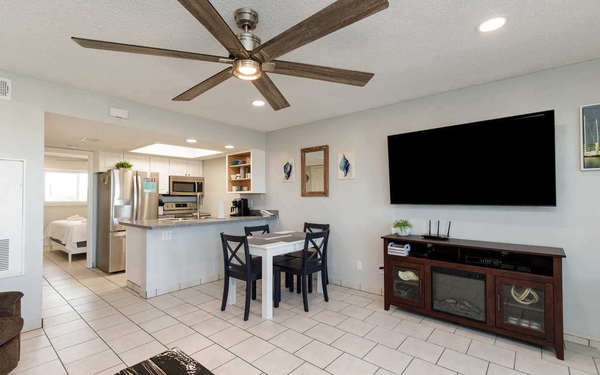 Relax in your open-concept living space with modern kitchen, dining area, and entertainment center—perfect for unwinding after beach days.