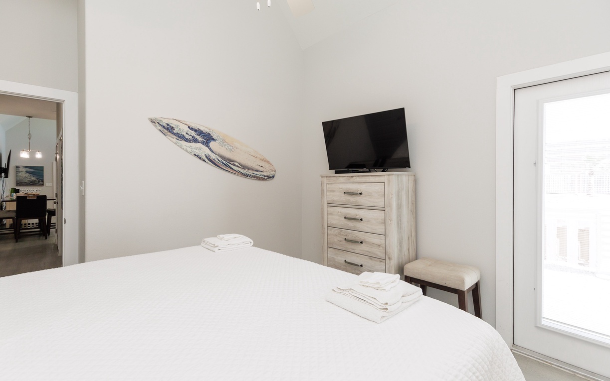 Unwind in your bright, airy bedroom with crisp linens, beachy decor, and entertainment at your fingertips.