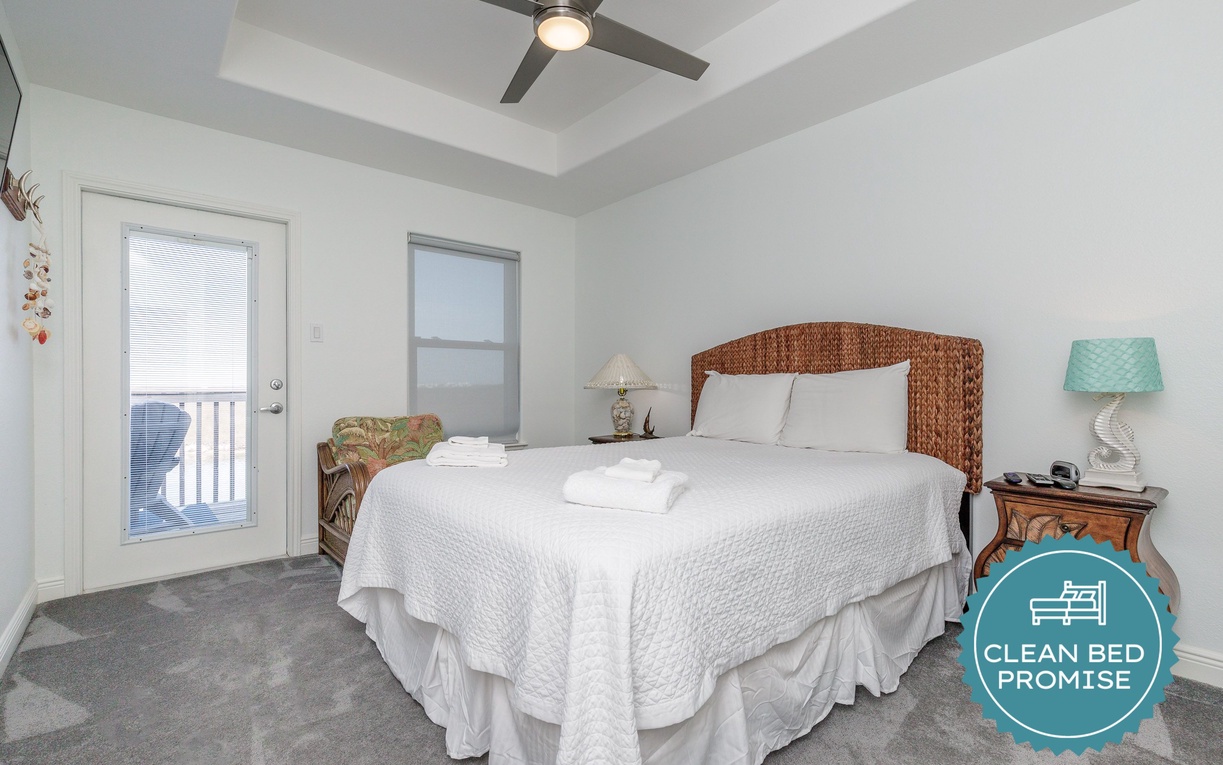 Drift into peaceful sleep on this plush bed with wicker headboard and soft linens, while the ceiling fan gently circulates cool air.
