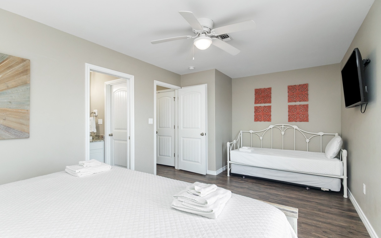 Unwind in your peaceful bedroom featuring a comfortable bed, daybed for extra guests, and wall-mounted TV for relaxing evenings.