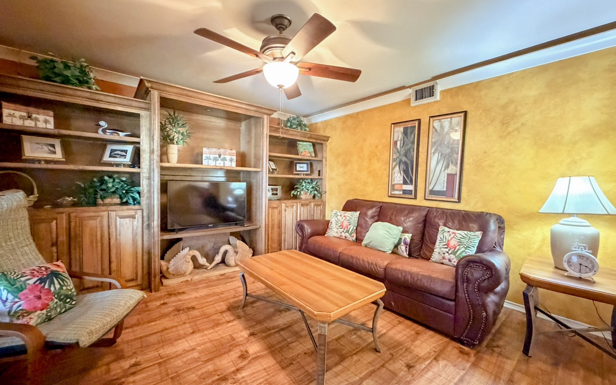 Settle into your comfortable leather sofa while tropical breezes from the ceiling fan keep you cool in this warm, inviting living space.