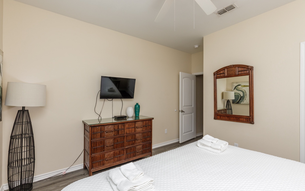 Relax in your serene bedroom with coastal-style bamboo furniture, flat-screen TV, and fresh linens waiting for your arrival.