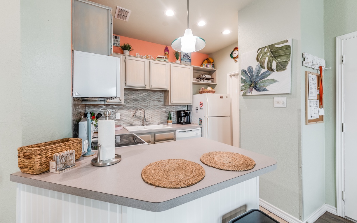 Your fully equipped kitchen awaits with modern appliances and coastal charm, perfect for preparing meals during your stay.