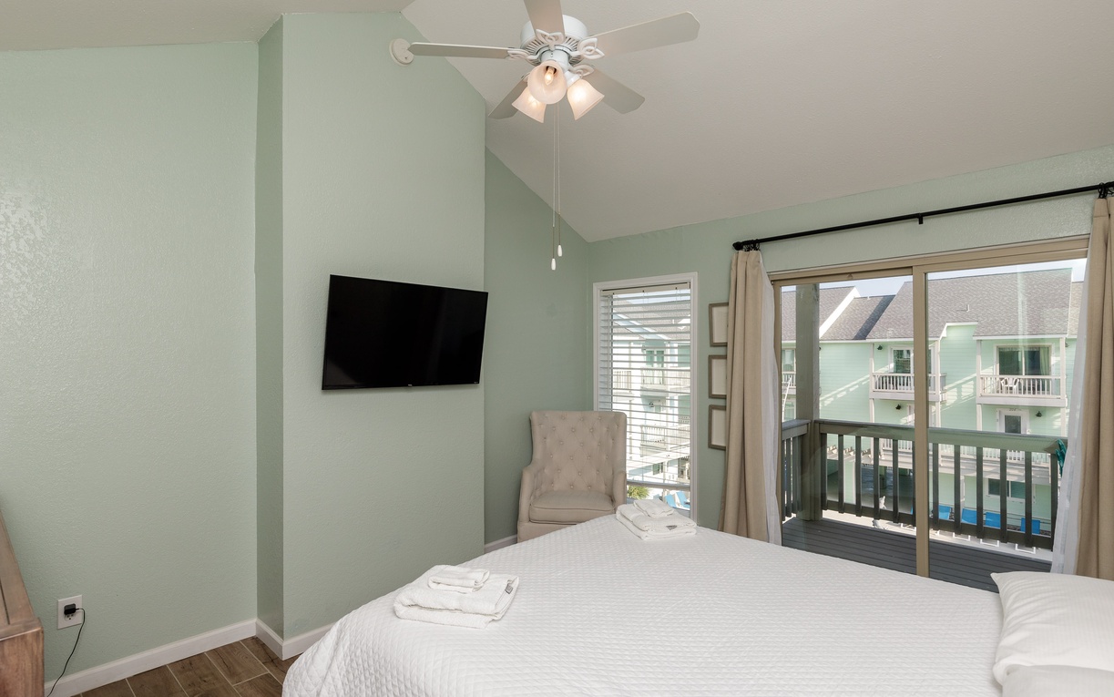 Drift off in your peaceful bedroom with calming mint walls, cozy linens, and a private balcony overlooking the neighborhood.