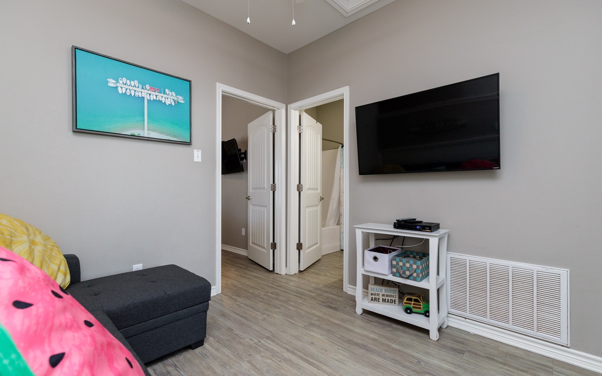 Settle in for movie nights in your cozy entertainment area with large TV, gaming systems, and colorful bean bag seating.