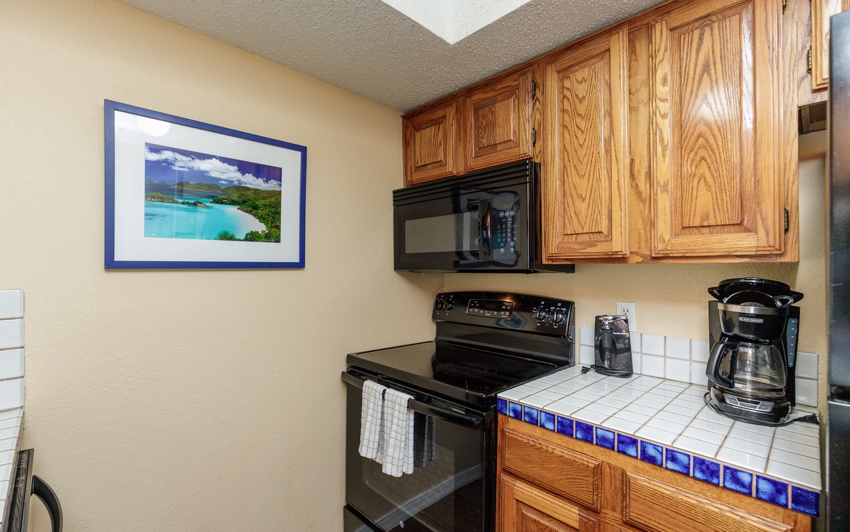 Your well-equipped kitchen features warm wood cabinetry and modern appliances, ready for preparing your favorite meals during your stay.