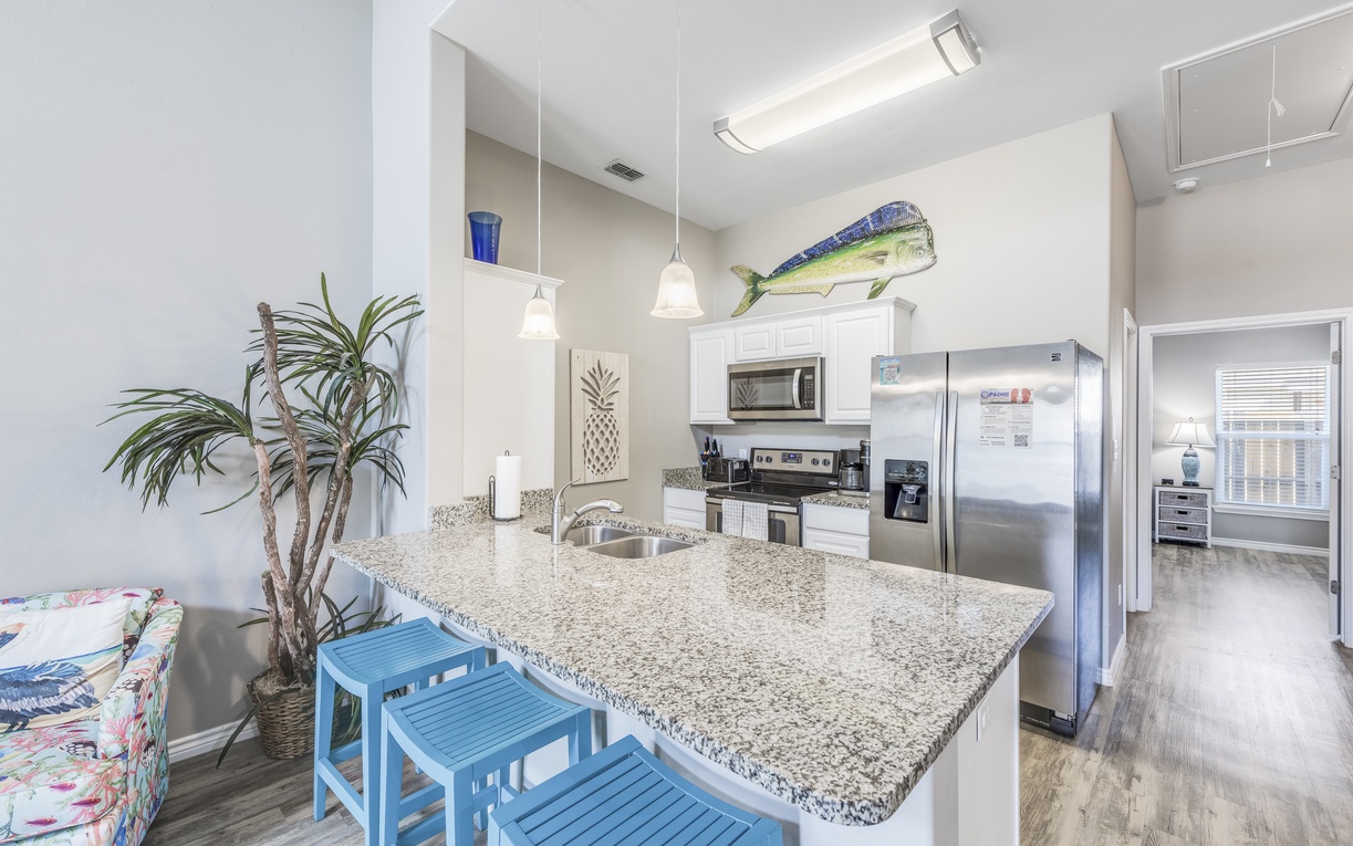 Your open kitchen features granite counters, stainless appliances, and coastal-themed touches that make cooking feel like a beach vacation.