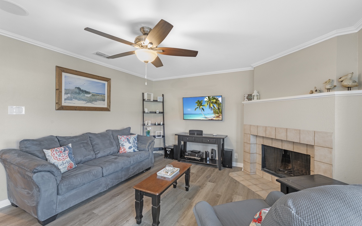 Unwind in your comfortable living room with plush seating, warm fireplace, and entertainment center for cozy evenings.