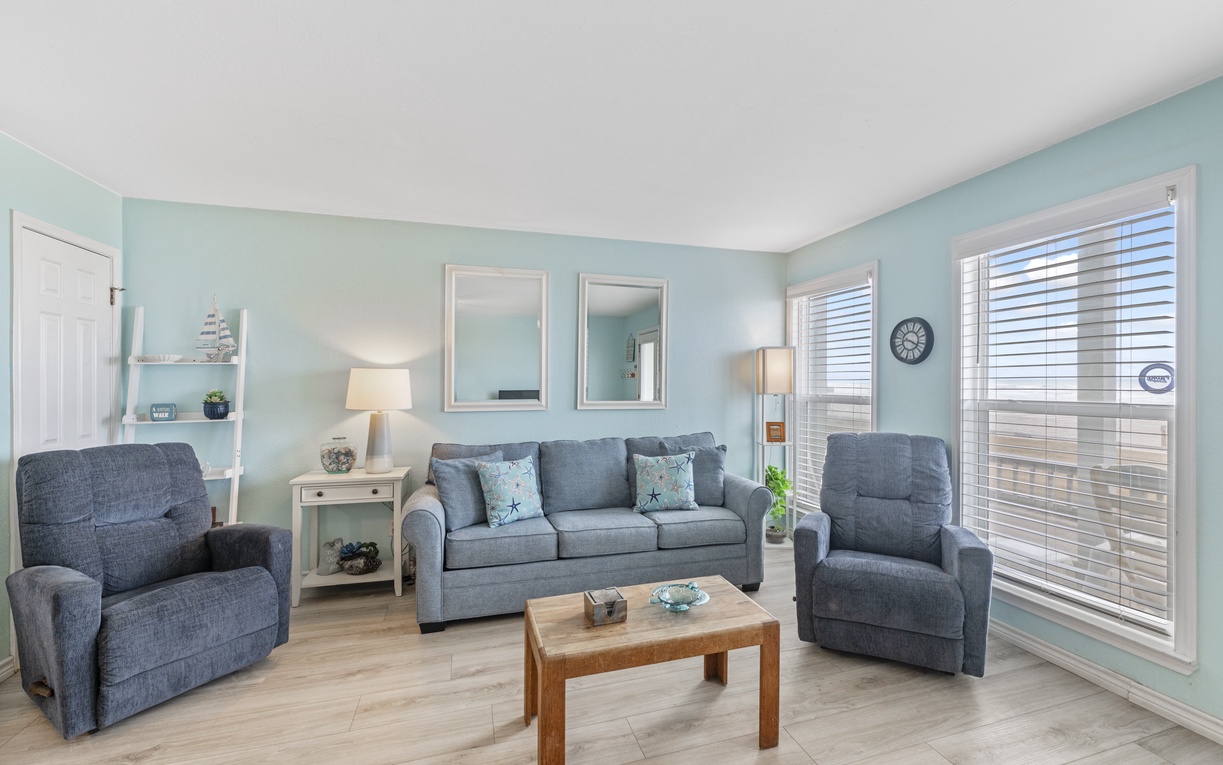 Unwind in your tranquil living room with soft blue walls, plush seating, and coastal charm that instantly puts you at ease.