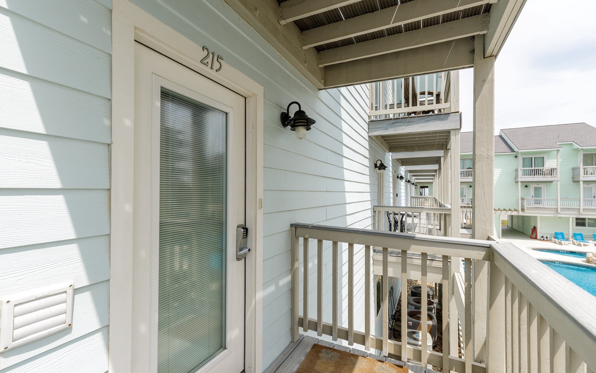 Front door and balcony that overlooks the sparkling pool, offering the perfect spot to unwind with morning coffee or evening cocktails.