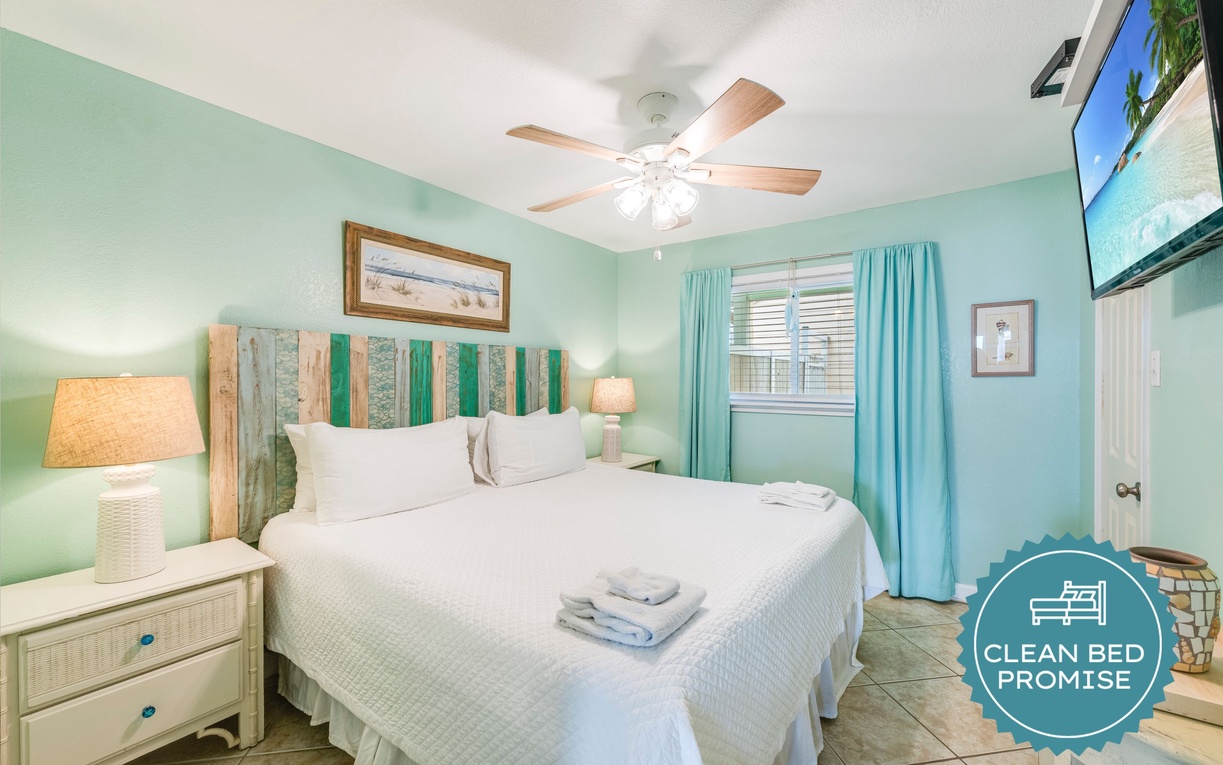 Drift into coastal dreams in your serene turquoise bedroom with crisp white linens and gentle ceiling fan breeze.