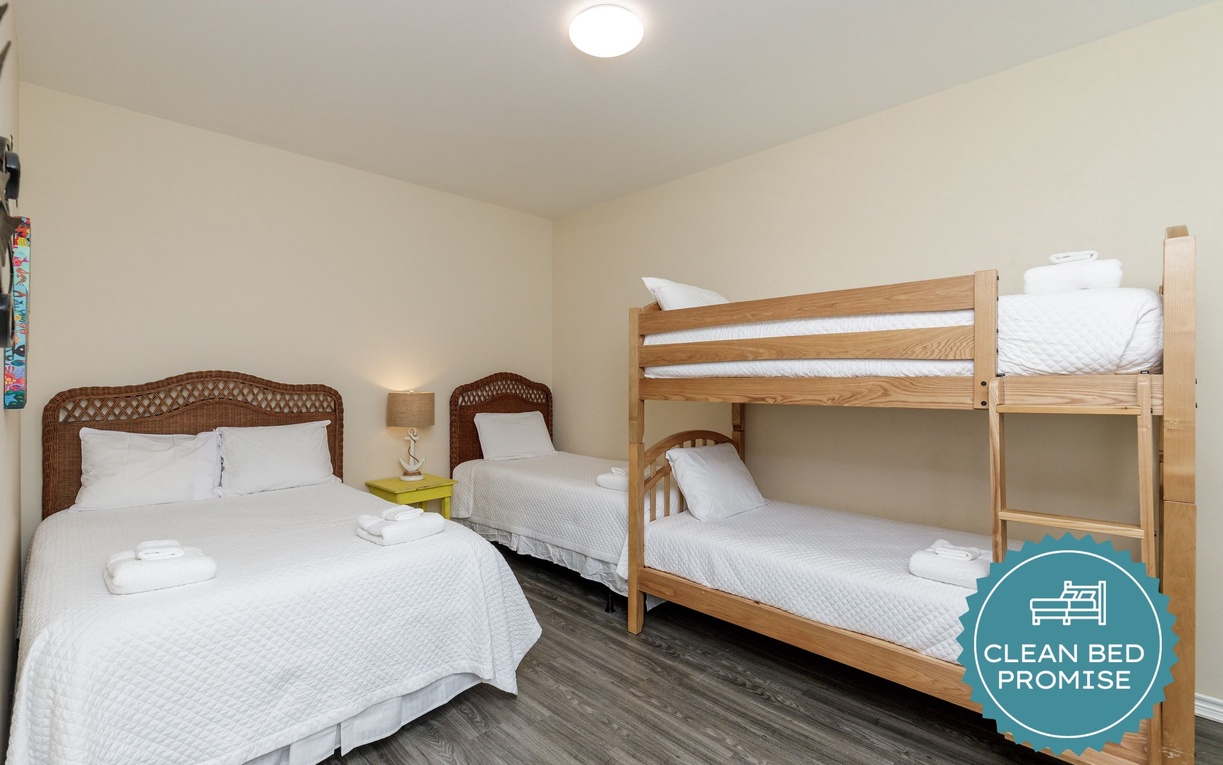 Bright family bedroom with fresh linens, wicker beds, and bunk beds—perfect for creating cozy memories with loved ones.