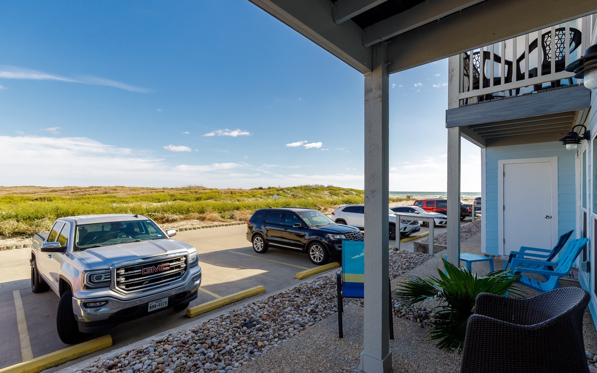 Relax on your private covered patio with outdoor seating while enjoying sweeping views of natural coastal dunes and convenient parking.