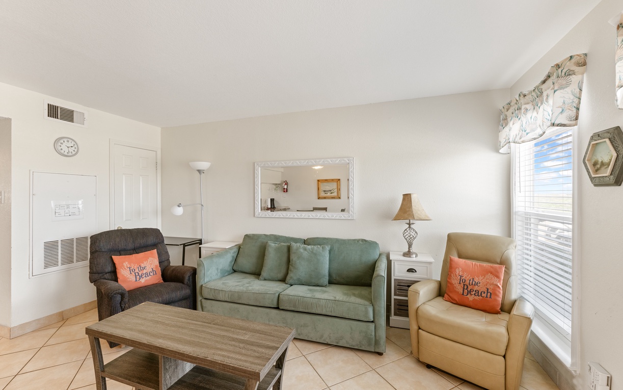 Unwind in your bright, coastal-themed living room with comfortable seating including a sleeper sofa.