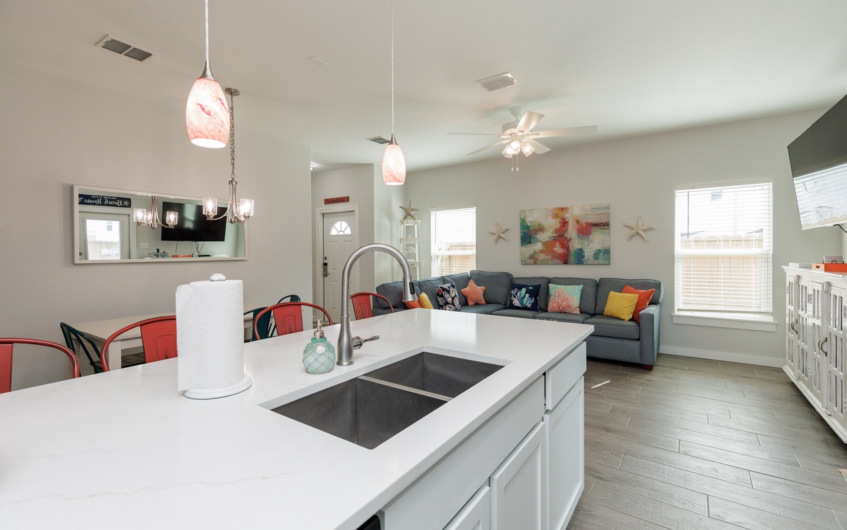 Gather around your open kitchen island where conversation flows as easily as meal prep, with the cozy living room just steps away.