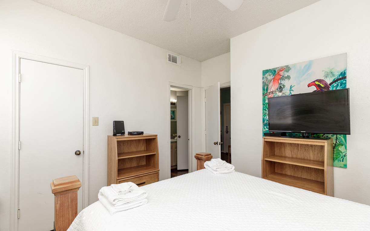 Rest peacefully in your bright bedroom with wooden furnishings and vibrant tropical artwork brightening your stay.