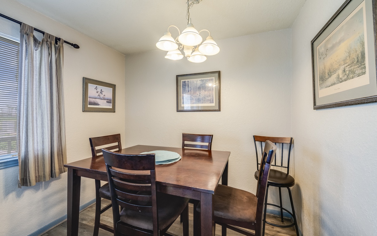 Gather around this elegant dining table for memorable meals together, with warm chandelier lighting creating the perfect atmosphere.