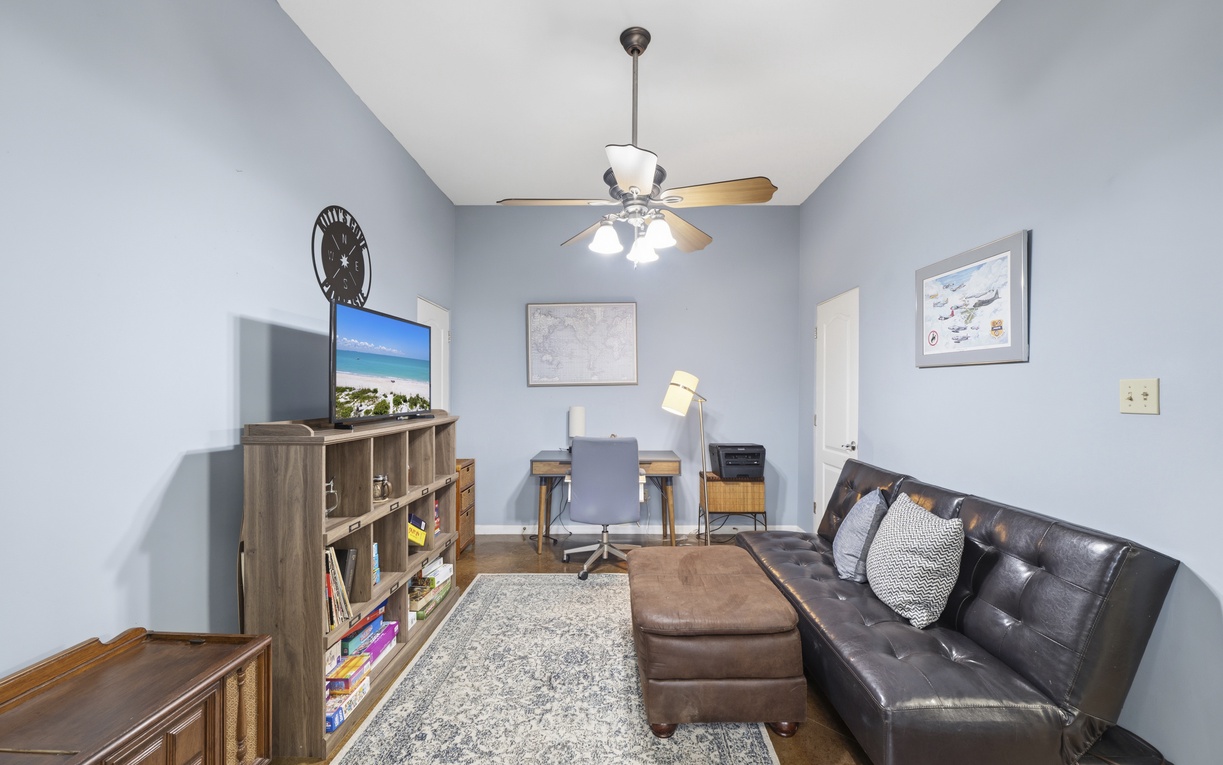 Settle into this calm, multi-purpose space where soft blue walls and comfortable seating create your perfect spot to work, relax, or unwind with entertainment.